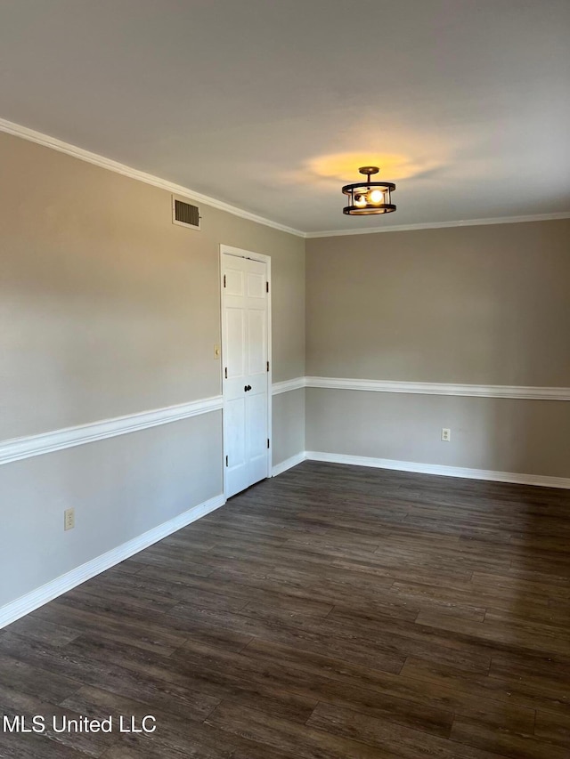 empty room with crown molding and dark wood-type flooring