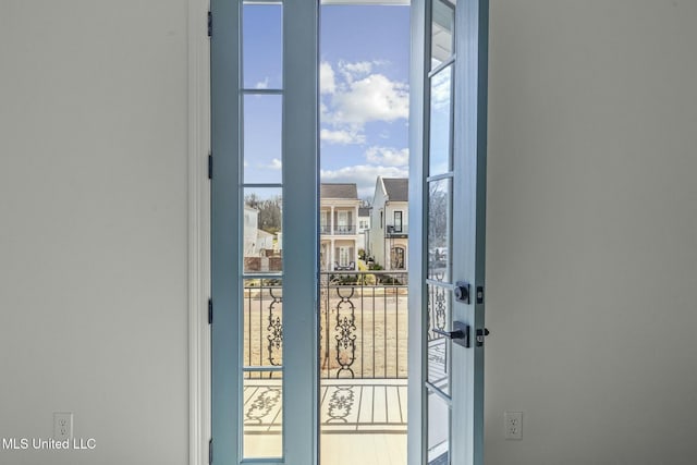 doorway with a wall of windows and a residential view