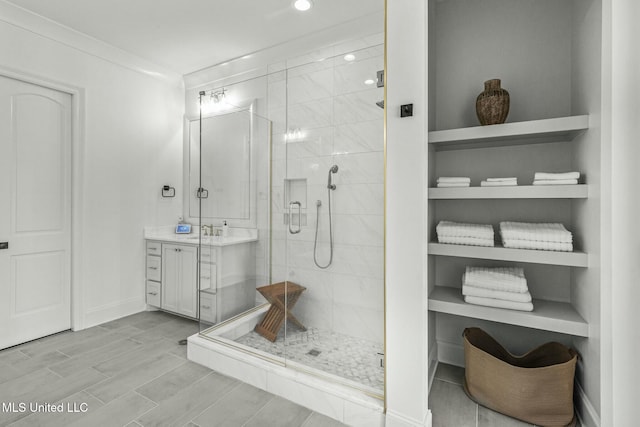 bathroom featuring vanity, a shower stall, baseboards, and wood tiled floor