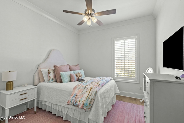 bedroom featuring baseboards, ceiling fan, crown molding, and light wood finished floors