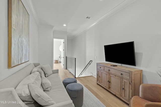 living area featuring recessed lighting, visible vents, light wood-style flooring, and ornamental molding