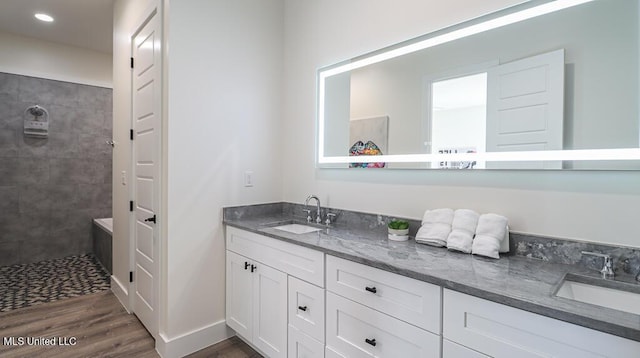 132 Markham Dr, Gulfport, MS 39507 - bathroom featuring double vanity, wood finished floors, tiled shower, and recessed lighting