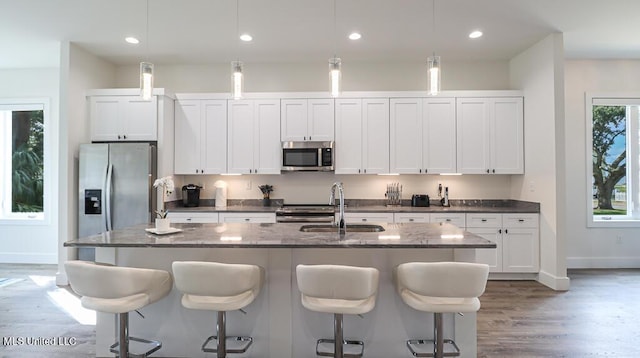 132 Markham Dr, Gulfport, MS 39507 - kitchen featuring stainless steel appliances, a sink, a kitchen island with sink, white cabinetry, and light wood finished floors