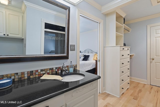 bathroom with hardwood / wood-style flooring, vanity, and ornamental molding