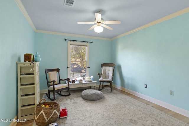 sitting room featuring hardwood / wood-style floors, ceiling fan, and ornamental molding