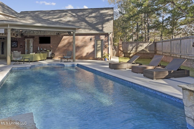 view of pool with outdoor lounge area, a patio, and ceiling fan