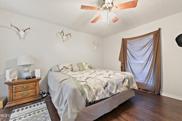 bedroom with ceiling fan and dark wood-type flooring