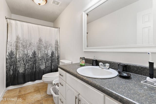 bathroom with vanity, a textured ceiling, and toilet