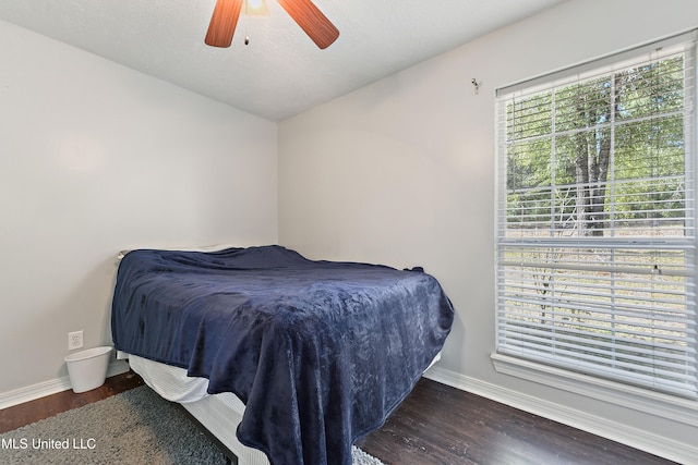 bedroom featuring ceiling fan, dark wood-type flooring, and vaulted ceiling