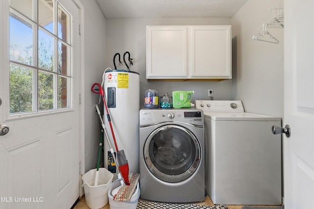 clothes washing area with water heater, washer and clothes dryer, light tile patterned floors, and cabinets