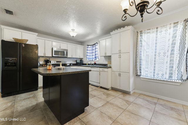 kitchen featuring a center island, an inviting chandelier, a textured ceiling, appliances with stainless steel finishes, and white cabinetry