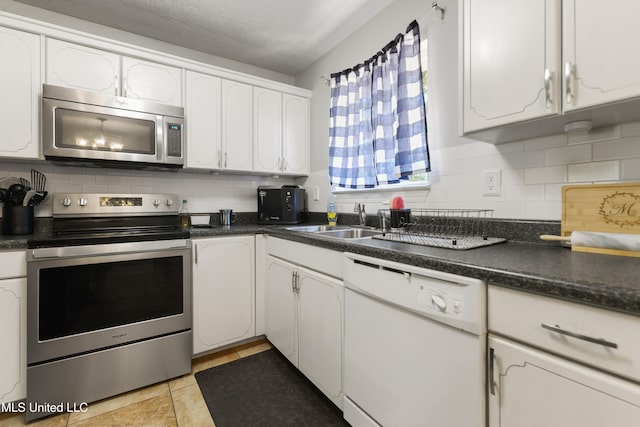 kitchen featuring backsplash, white cabinetry, and stainless steel appliances