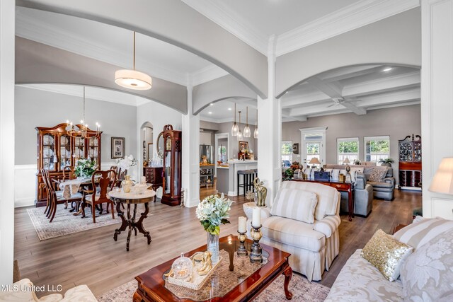 12578 Alphabet Rd, Gulfport, MS 39503 - living room with arched walkways, a chandelier, wood finished floors, decorative columns, and beam ceiling