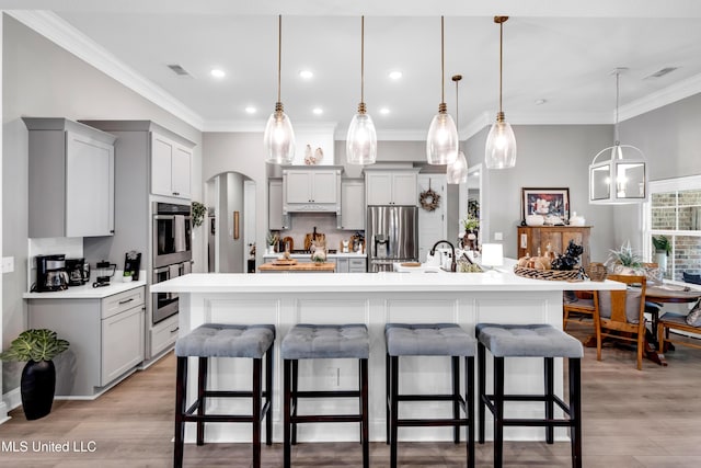 12578 Alphabet Rd, Gulfport, MS 39503 - kitchen with stainless steel appliances, gray cabinets, light countertops, crown molding, and a breakfast bar