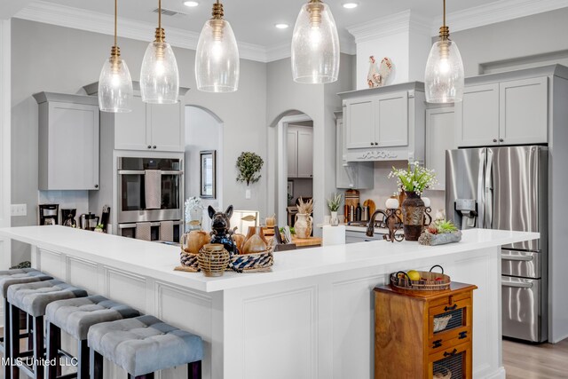 12578 Alphabet Rd, Gulfport, MS 39503 - kitchen featuring appliances with stainless steel finishes, arched walkways, light countertops, crown molding, and recessed lighting