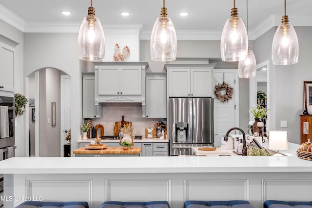 12578 Alphabet Rd, Gulfport, MS 39503 - kitchen featuring appliances with stainless steel finishes, arched walkways, crown molding, pendant lighting, and a breakfast bar area