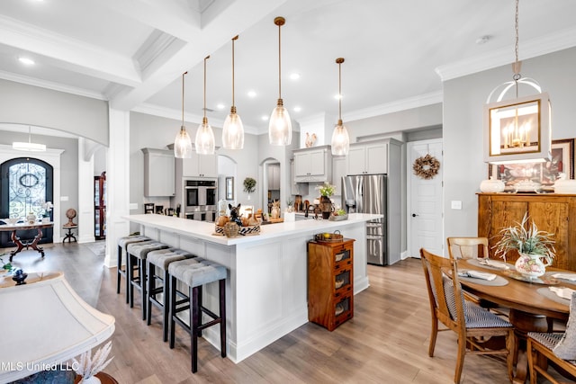 12578 Alphabet Rd, Gulfport, MS 39503 - kitchen featuring arched walkways, appliances with stainless steel finishes, light countertops, a breakfast bar area, and crown molding