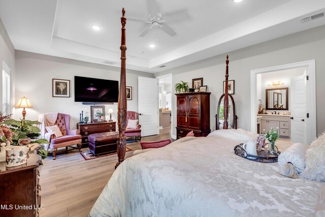 12578 Alphabet Rd, Gulfport, MS 39503 - bedroom featuring a tray ceiling, light wood-style floors, recessed lighting, and connected bathroom