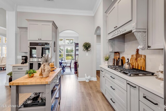 12578 Alphabet Rd, Gulfport, MS 39503 - kitchen with arched walkways, stainless steel appliances, wooden counters, light wood-style flooring, and baseboards