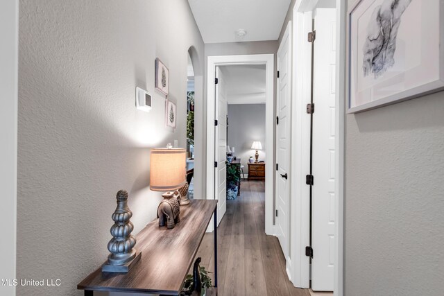 12578 Alphabet Rd, Gulfport, MS 39503 - hallway featuring a textured wall, wood finished floors, and arched walkways