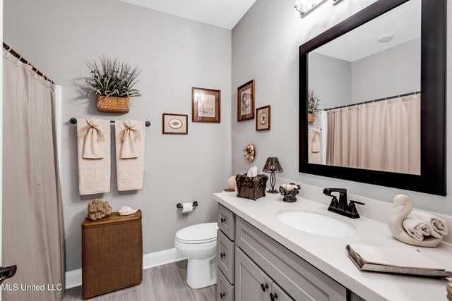 12578 Alphabet Rd, Gulfport, MS 39503 - bathroom featuring vanity, toilet, baseboards, wood finished floors, and a shower with curtain