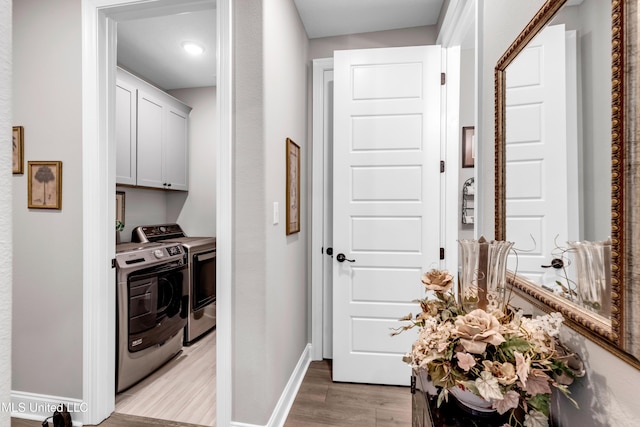 12578 Alphabet Rd, Gulfport, MS 39503 - laundry area featuring cabinet space, washer and clothes dryer, baseboards, and light wood-style floors