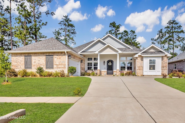 12578 Alphabet Rd, Gulfport, MS 39503 - craftsman-style home with an attached garage, concrete driveway, a front yard, brick siding, and a shingled roof