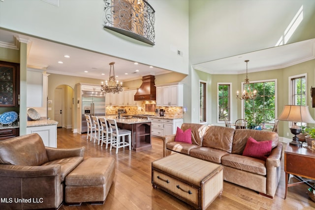 4666 Eiffel Ln, Nesbit, MS 38651 - living area featuring a chandelier, light wood-style floors, arched walkways, ornamental molding, and recessed lighting