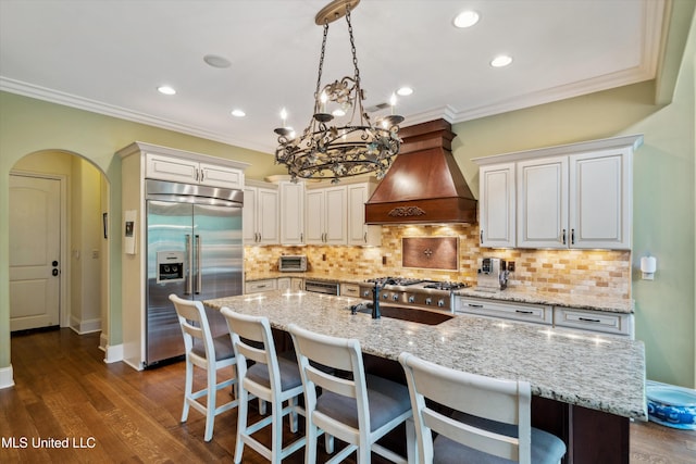 4666 Eiffel Ln, Nesbit, MS 38651 - kitchen with stainless steel built in refrigerator, custom range hood, crown molding, dark wood-style floors, and decorative backsplash
