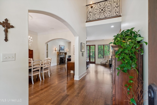 4666 Eiffel Ln, Nesbit, MS 38651 - entrance foyer with a fireplace, wood finished floors, arched walkways, baseboards, and ornamental molding