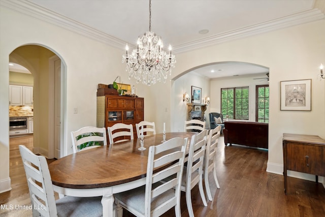 4666 Eiffel Ln, Nesbit, MS 38651 - dining space featuring arched walkways, wood finished floors, crown molding, a chandelier, and baseboards