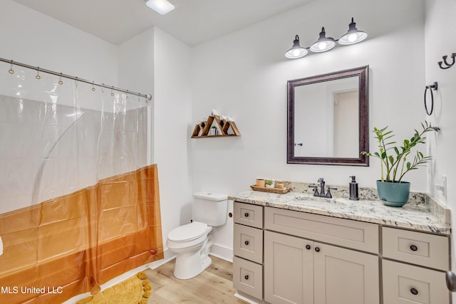 bathroom featuring toilet, vanity, a shower with shower curtain, and hardwood / wood-style flooring