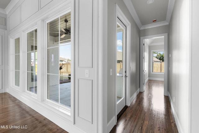 hall with ornamental molding and dark wood-type flooring