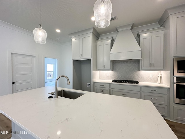 kitchen featuring tasteful backsplash, ornamental molding, custom exhaust hood, stainless steel appliances, and a sink