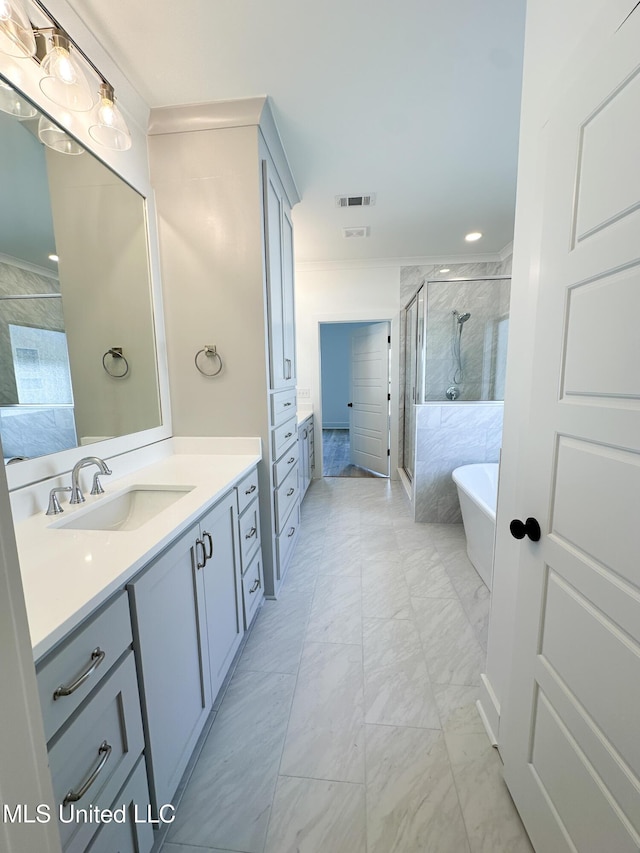 full bath featuring a stall shower, visible vents, marble finish floor, vanity, and a freestanding tub