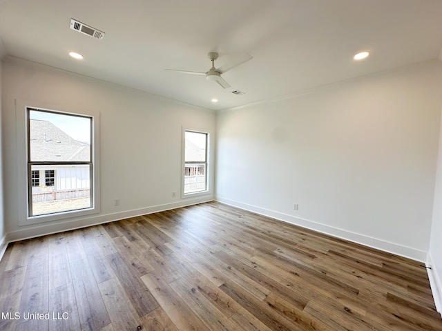 unfurnished room featuring hardwood / wood-style flooring, recessed lighting, visible vents, and baseboards