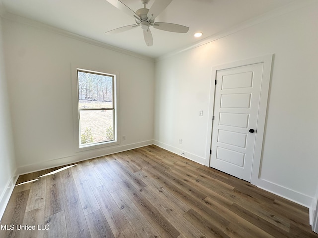 unfurnished room with ornamental molding, wood finished floors, a ceiling fan, and baseboards