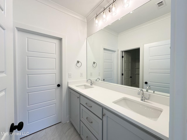 full bathroom featuring marble finish floor, ornamental molding, a sink, and visible vents