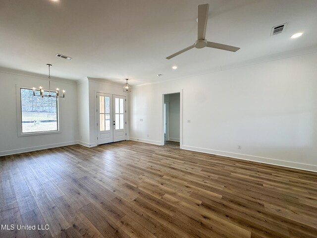 empty room with baseboards, dark wood-type flooring, visible vents, and crown molding