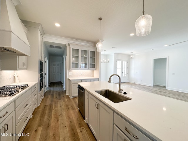 kitchen with stainless steel gas cooktop, custom exhaust hood, visible vents, a sink, and dishwashing machine