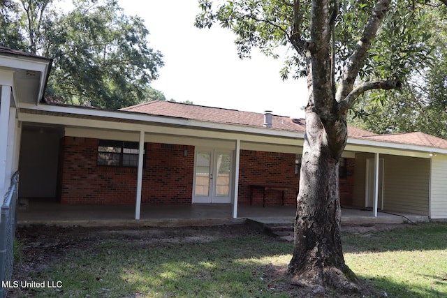 back of property with a patio area and a lawn