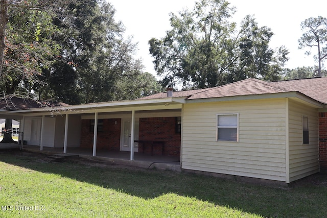 back of house with a patio area and a lawn