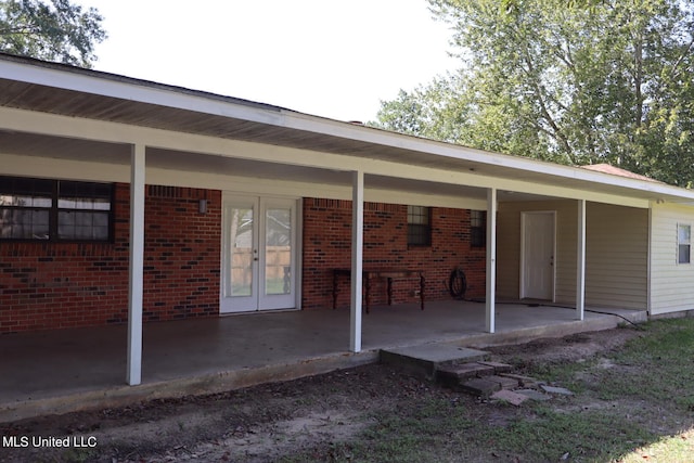 back of house featuring french doors and a carport