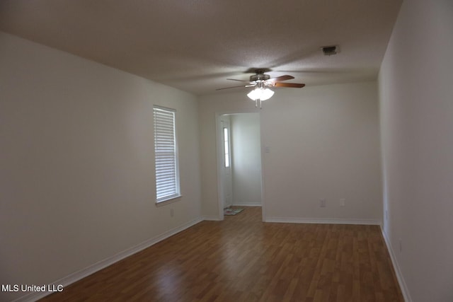 unfurnished room featuring ceiling fan and dark hardwood / wood-style floors