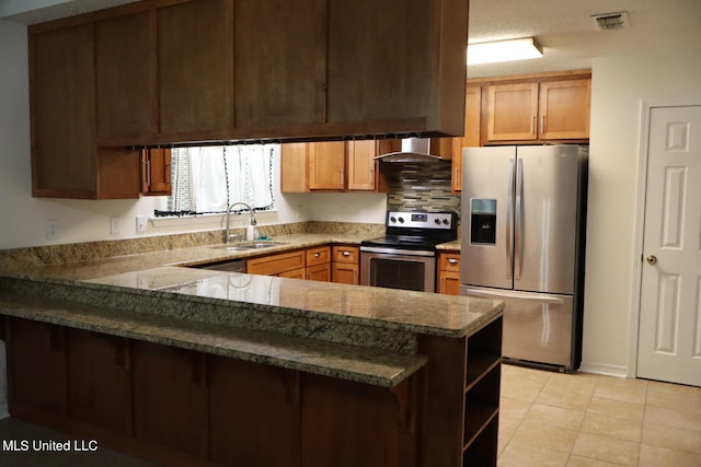 kitchen featuring wall chimney range hood, kitchen peninsula, light tile patterned floors, sink, and stainless steel appliances