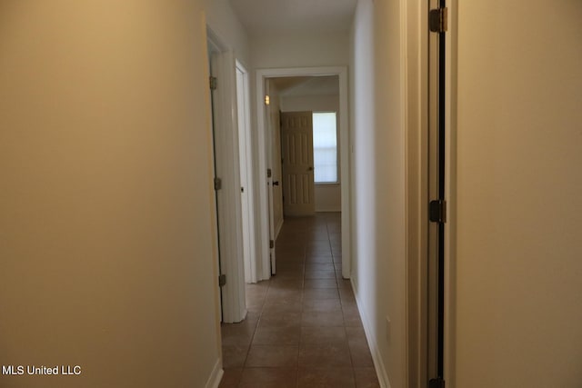 hall with dark tile patterned flooring