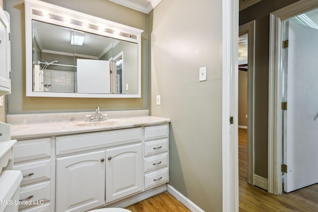 bathroom with vanity, crown molding, and hardwood / wood-style flooring