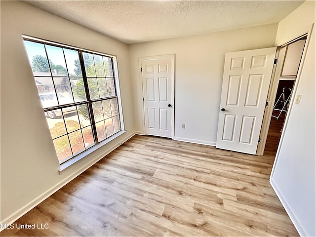 7164 Kimlee Cv, Southaven, MS 38671 - unfurnished bedroom featuring light wood-style flooring, a textured ceiling, and baseboards