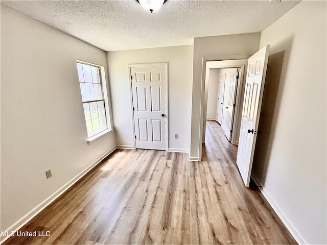 7164 Kimlee Cv, Southaven, MS 38671 - unfurnished bedroom with wood finished floors, a textured ceiling, and baseboards