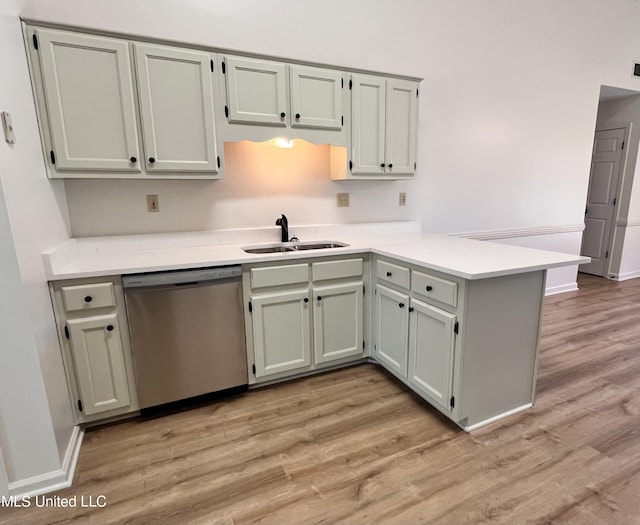 7164 Kimlee Cv, Southaven, MS 38671 - kitchen featuring stainless steel dishwasher, a sink, a peninsula, light wood-style floors, and light countertops